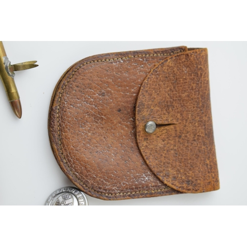 27 - A collection of military items to include A.R.P silver badge, Leather WWi pocket watch case and othe... 