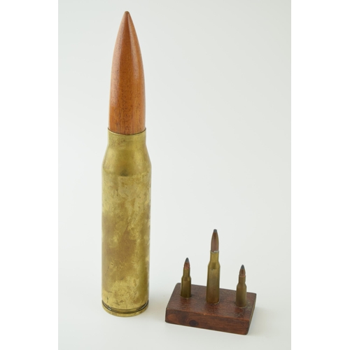 31 - A practice shell, height 27cm together with three mounted bullets. (2)