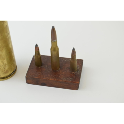 31 - A practice shell, height 27cm together with three mounted bullets. (2)