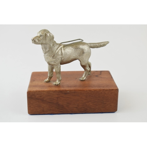 76 - A pewter model of a guide dog, mounted on wooden plinth, 12cm tall.