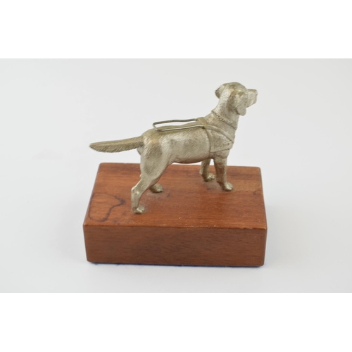 76 - A pewter model of a guide dog, mounted on wooden plinth, 12cm tall.