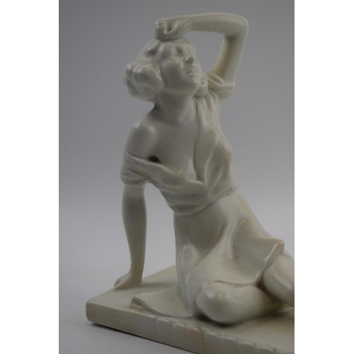 221 - Art Deco figure, circa 1930s, of a lady sat wiping her brow, indistinct marks to base, perhaps reads... 