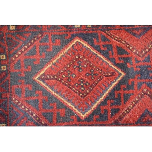 214 - A Middle Eastern runner rug in blue, reds and cream. Length 268cm x 65cm.