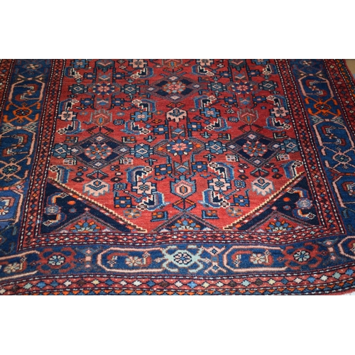 215 - A Middle Eastern rug in blue, reds and cream. Length 210cm x 125cm.