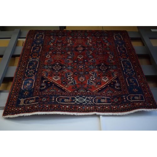 215 - A Middle Eastern rug in blue, reds and cream. Length 210cm x 125cm.