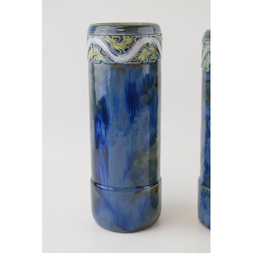 240 - A near pair of Royal Doulton stoneware cylindrical vases, with tubelined decoration to the tops, on ... 