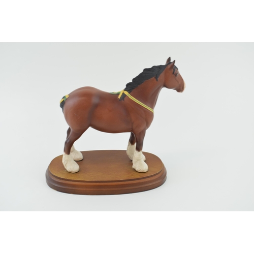 22 - Boxed Royal Doulton bay shire horse with yellow and green ribbon, on wooden base, 19cm wide.