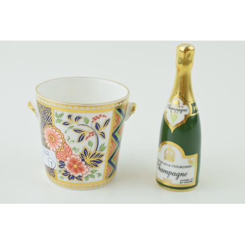 35 - A Royal Crown Derby miniature Champagne bottle together with a two handled cup. Height 9cm. (2)