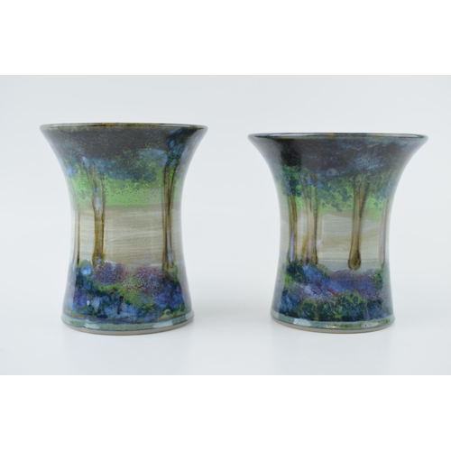 95 - A pair of Highland Stoneware pottery vases, with a forest, signed to base, 12cm tall.