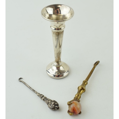 490 - A small silver loaded vase, gross 12.3g, with a miniature silver button hook and one similar (3).