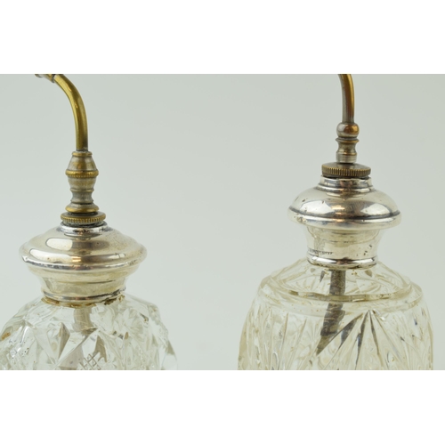 499 - A near pair of silver collared spray scent bottles, stamped sterling, 16cm tall (2).