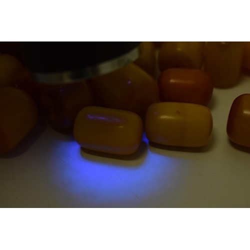 526 - A collection of loose butterscotch amber (or similar) beads, all drilled, circa 186g, varying sizes.