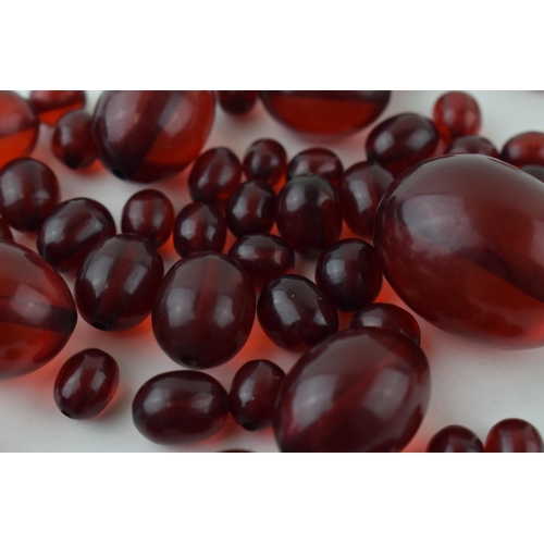 527 - A collection of cherry amber (or similar) to include graduated beads of varying sizes, 64.8g.