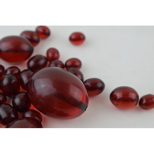 527 - A collection of cherry amber (or similar) to include graduated beads of varying sizes, 64.8g.