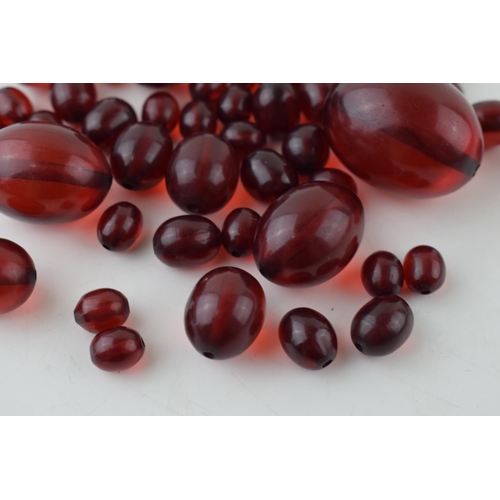 527 - A collection of cherry amber (or similar) to include graduated beads of varying sizes, 64.8g.