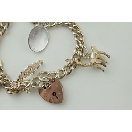 547 - Silver charm bracelet, 47.4g, to include a jester, a llama, a temple and others.