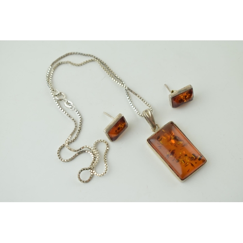 553 - A silver amber pendant, set in silver, on silver chain, with matching earring set (3).