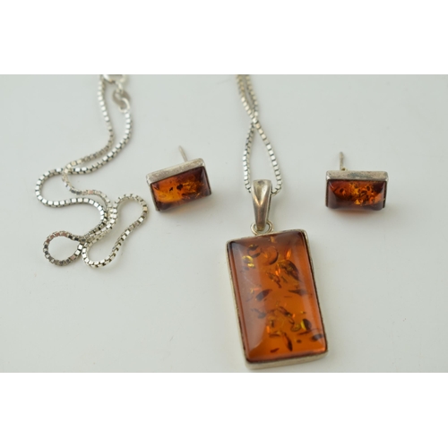 553 - A silver amber pendant, set in silver, on silver chain, with matching earring set (3).