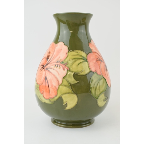 204 - Moorcroft bulbous vase in the Hibiscus pattern, on green, 20.5cm tall.