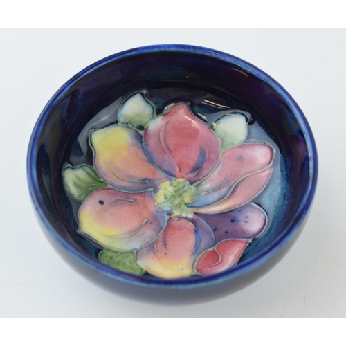 209 - Moorcroft small dish with early floral decoration, blue background, 8cm diameter.