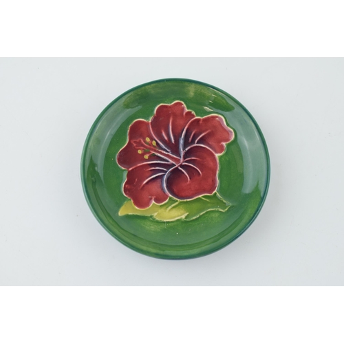 215 - Moorcroft hibiscus on green pin dish, 7.5cm diameter.