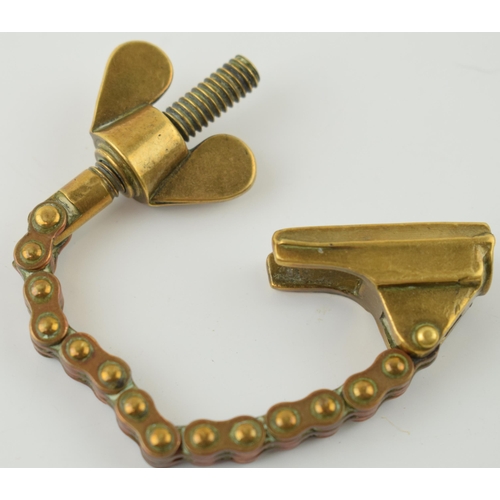 34 - Antique brass novelty bottle top remover, tension and screw type movement, 14cm long.