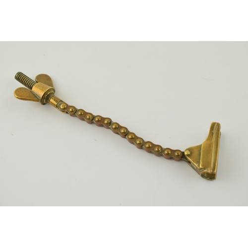 34 - Antique brass novelty bottle top remover, tension and screw type movement, 14cm long.