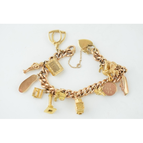 A yellow gold charm bracelet. 15ct gold Victorian Albert chain with 14 individual 9ct yellow gold vintage charms. Gross weight 70.8 grams.