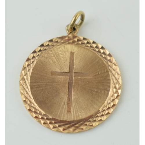 563 - A 9ct yellow gold circular pendant with central cross. Diameter 1.7cm. Weight 3 grams.