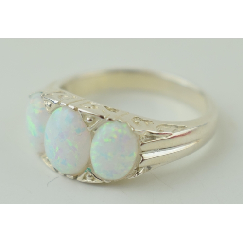 575 - A sterling silver contemporary ring set with Opal style stones. Ring size 'O'.