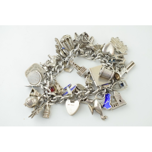 579 - Heavy silver charm bracelet, 128.2g, to include a lantern, a lamp, clogs, a pumpkin and others, over... 