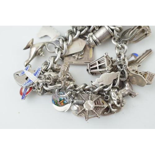 579 - Heavy silver charm bracelet, 128.2g, to include a lantern, a lamp, clogs, a pumpkin and others, over... 