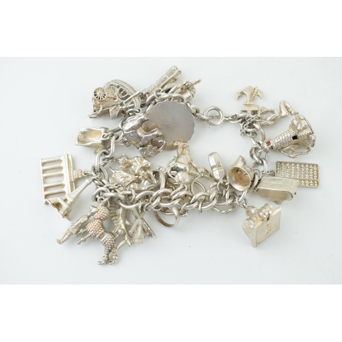 580 - Silver charm bracelet to include the Eiffel Tower, cupid, rings, a tankard and others, 79.5g.