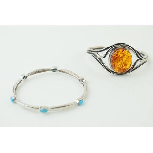 581 - A pair of silver stone set bangles, one with amber and the other turqouise (2), 38g.