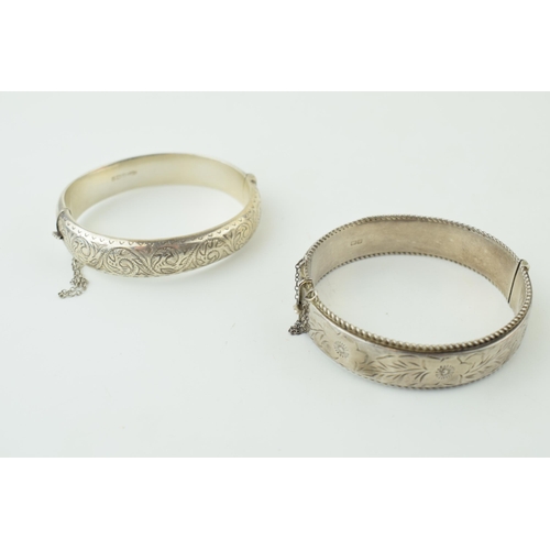 582 - Two silver engraved bangles / bracelets, working clasps, engraved floral decoration, 45g (2).