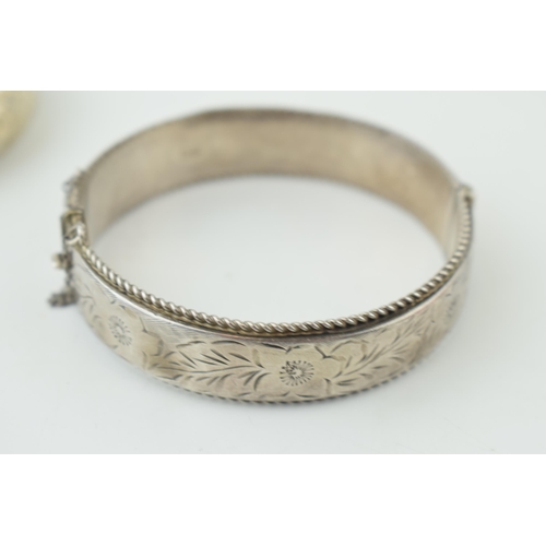 582 - Two silver engraved bangles / bracelets, working clasps, engraved floral decoration, 45g (2).