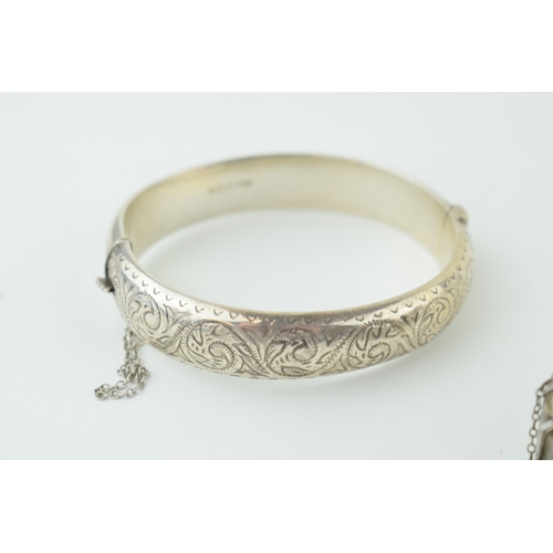 582 - Two silver engraved bangles / bracelets, working clasps, engraved floral decoration, 45g (2).