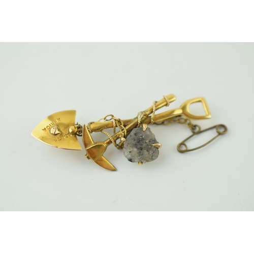 587 - 9ct gold miners brooch, stamped 'South Africa' and '9ct', set stone, 46mm, with metal safety chain.