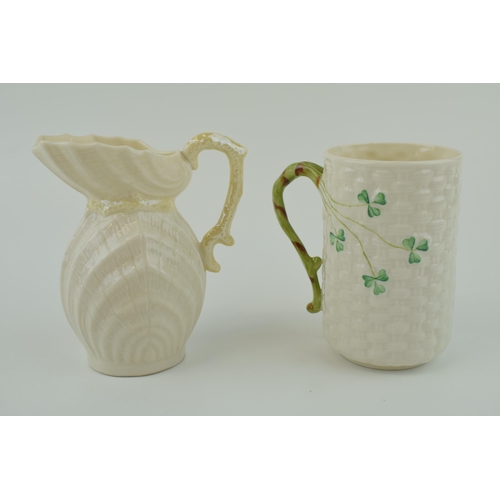 102 - A Belleek shell ribbed jug with ornate handle (chip to handle) with a wicker effect cup (2), tallest... 