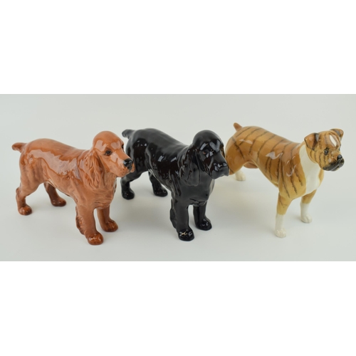 33 - Three Beswick dogs to include a brindle boxer dog together with two spaniels (3).