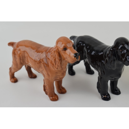 33 - Three Beswick dogs to include a brindle boxer dog together with two spaniels (3).