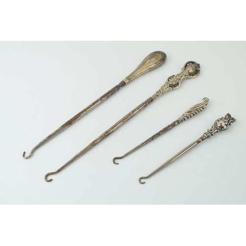 524 - Silver button hooks to include two oversized examples, 26cm long, one ornately pierced, with two sma... 