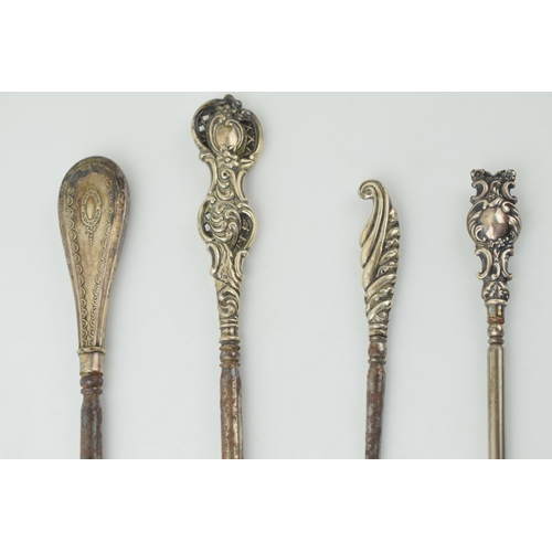 524 - Silver button hooks to include two oversized examples, 26cm long, one ornately pierced, with two sma... 