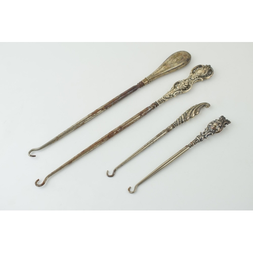 524 - Silver button hooks to include two oversized examples, 26cm long, one ornately pierced, with two sma... 