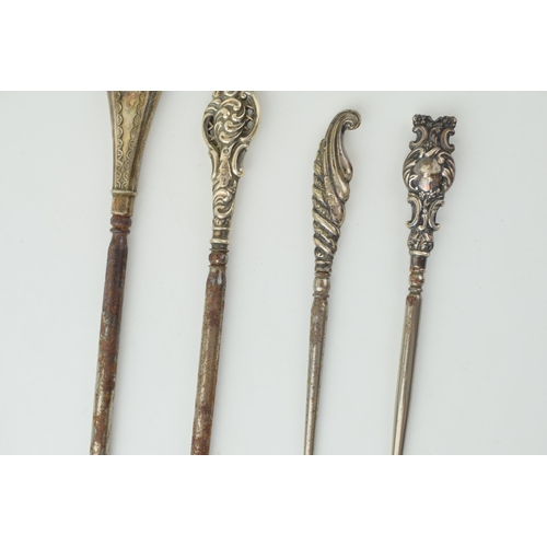 524 - Silver button hooks to include two oversized examples, 26cm long, one ornately pierced, with two sma... 