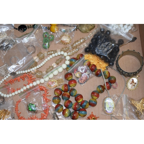 592 - A collection of costume jewellery to include a medal, bangles, a multicoloured glass necklace, rings... 