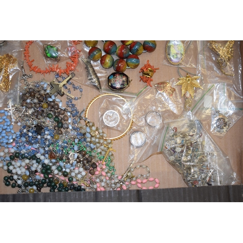 592 - A collection of costume jewellery to include a medal, bangles, a multicoloured glass necklace, rings... 