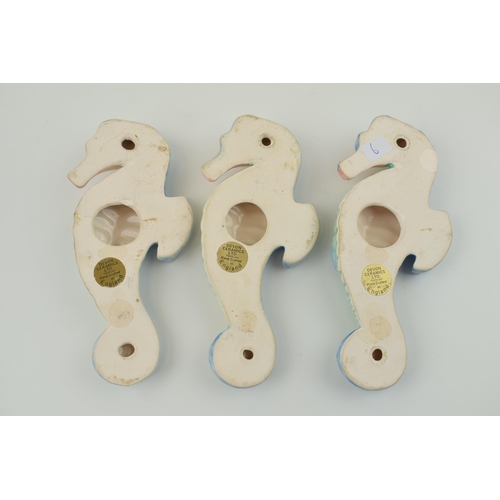 87 - A trio of Devon Ceramics Ltd wall plaques in the form of sea horses, 17.5cm tall (3).