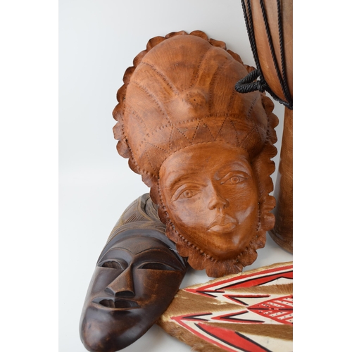 100 - A collection of African and Indonesian items to include carved busts and wall masks together with a ... 