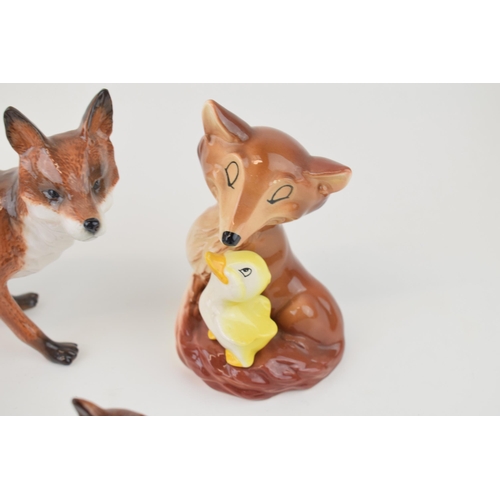 53 - A collection of pottery fox figures to include a modern John Beswick example, a Hornsea fox with duc... 